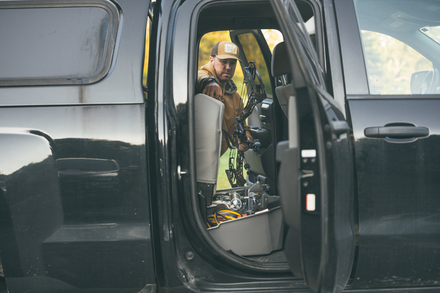 Used to navigate to the under seat collection page. Background is a man holding a bow and grabbing something from his under seat storage in his truck.